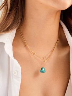 Opt for a little self love in your stack when you choose the Juno Necklace. This piece features a dainty gold chain complete with a heart-shaped pendant, made with natural turquoise stone. Turquoise represents and brings luck, peace, and protection, so this piece is sure to add good vibes to your necklace collection. Turquoise Charm Necklace With Delicate Chain, Gold Turquoise Gemstone Necklace In Dainty Style, Dainty Turquoise Pendant Necklace, Dainty Turquoise Necklace For Gift, Dainty Gold Turquoise Gemstone Necklace, Dainty Yellow Gold Turquoise Necklace For Gift, Dainty Heart Pendant Necklace For May Birthstone, Dainty Heart-shaped Layered Necklace For Gift, Dainty Layered Heart Necklace For Gifts