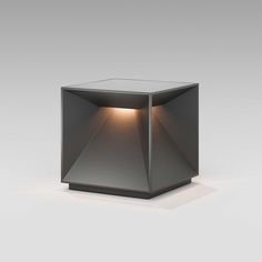 a small square light sitting on top of a white floor next to a gray wall