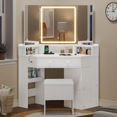 a white vanity with lighted mirror and stool in front of a clock on the wall