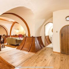 a living room filled with furniture next to a kitchen and dining room table in front of an arched doorway