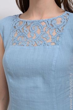 a woman wearing a blue dress with an intricate lace detail