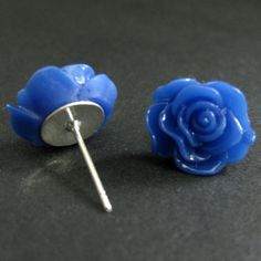 A set of bright royal blue colored resin roses decorate silver plated stud earrings (no nickel) in this pair of handmade earrings that also come with a matching set of silver plated earring backs.Size: 14mm rosesThese earrings are available in a variety of colors! http://etsy.me/1rv1YFVThey are also available as dangle earrings!Bronze - https://www.etsy.com/stumblingonsainthood/listing/106361809Silver - https://www.etsy.com/stumblingonsainthood/listing/113486696If you would like to order a large Blue Round Flower Earrings In Sterling Silver, Nickel-free Blue Flower Earrings, Blue Flower-shaped Sterling Silver Earrings, Blue Flower-shaped Summer Earrings, Blue Flower Stud Earrings, Blue Flower-shaped Resin Earrings, Blue Stud Earrings, Blue Rose, Rose Earrings