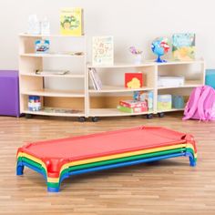 a child's play room with bookshelves and toys on the floor in front of it