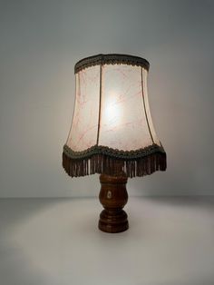 a lamp that is sitting on top of a table with a white light behind it