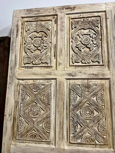 an old wooden door with intricate carvings on the front and side panels, in whitewashed wood