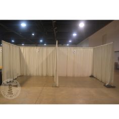 an empty room with white curtains and lights