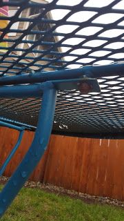 a blue metal chair sitting in front of a wooden fence