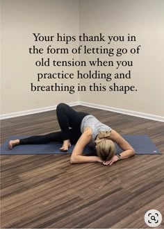 a woman is doing yoga on the floor in front of a wall with an inspirational quote