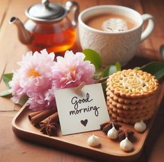 there is a cup of tea and some cookies on the tray next to it are flowers