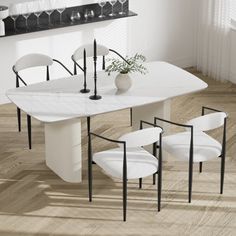 a white dining table with four chairs and a vase on the end, in front of a mirror