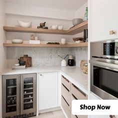 a kitchen with white cabinets and open shelves