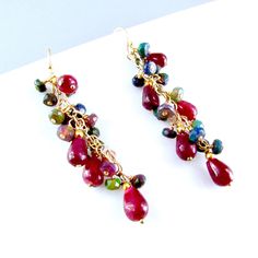 "Stunning smooth red rubies and gorgeous black faceted  Ethiopian opals are paired up to create these striking earrings. The ruby gemstones are a nice generous size measuring approximately 5-8 mm. The gems are wrapped gold filled wire and pins and then attached to a length of gold filled chain. The earrings measures 2 1/8\" from the top of the ear wires." Red Dangle Jewelry With Gemstone Accents, Red Gemstone Accented Drop Earrings, Ruby Gemstone Briolette Earrings, Ethiopian Opal Earrings, Peacock Pearl, Star Ruby, Green Opal, Gold Filled Earrings, Ruby Gemstone