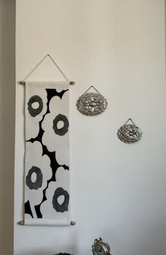 the wall is decorated with black and white flowers, hanging from hooks on it's side