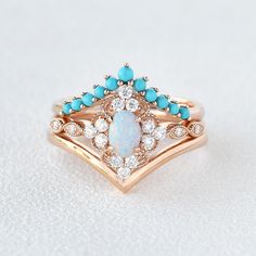 an opal and diamond ring is shown on a white surface with blue stones in the center