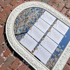 a white frame sitting on top of a brick floor