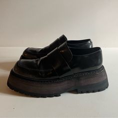 Buffed Leather Loafers In Black. Fading Throughout. Square Toe. Tonal Leather Strap At Vamp. Tonal Suede And Buffed Leather Lining. Platform Midsole. Treaded Rubber Outsole. Approx. 1.75 Platform. Black With Unique Gray Fading Throughout. Black Pointed Toe Loafers With Textured Sole, Black Patent Leather Loafers With Square Toe, Black Patent Leather Loafers With Textured Sole, Black Loafers With Contrast Sole And Flat Heel, Black Platform Loafers With Brogue Detailing For Business, Classic Black Platform Loafers With Vibram Sole, Black Leather Platform Loafers With Vibram Sole, Black Slip-on Loafers With Vibram Sole, Black Business Platform Loafers With Vibram Sole