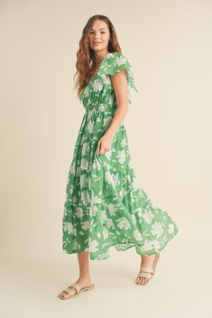 FINAL SALE this green and white floral dress from wishlist is giving me vacay vibes! perfect for a night out, sipping your favorite bev. it's also a lovely dress for a summer wedding or a bridal shower. a maxi dress with flutter sleeves, an elegant neckline, smocking at the waist and back, with a tiered skirt. it's lined and has pockets. you will look timeless in this dress. pair with some subtle jewelry and accessories and the perfect sandals to complete the look! our model is wearing a size sm Breezy Green Maxi Dress, Green Breezy Maxi Dress, Green Maxi Dress With Floral Print For Garden Party, Spring Green Floral Print Maxi Dress, Breezy Floral Print Maxi Dress, Green Floral Maxi Dress For Garden Party, Green Maxi Sundress For Brunch, Green Floral Print Maxi Dress For Spring, Green Sundress Maxi Dress For Brunch