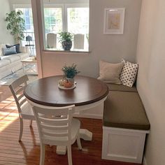 a dining room table with two chairs and a bench in front of the window next to it