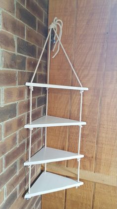 a white shelf hanging from the side of a brick wall