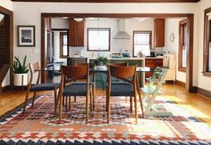 a dining room table with chairs and a rug on the floor