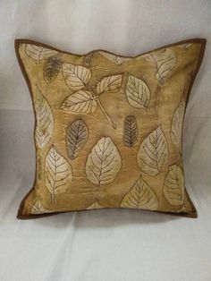 an embroidered pillow with leaves on it