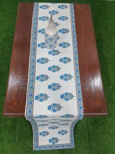 a long table with blue flowers on it and a vase sitting on top of it