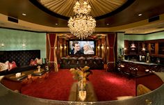 a living room filled with lots of furniture and a chandelier hanging from the ceiling