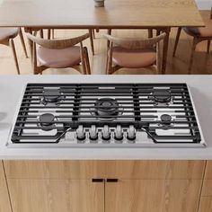 a stove top oven sitting inside of a kitchen next to a dining room table and chairs