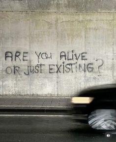 graffiti on the side of a building that says are you alive or just existing?