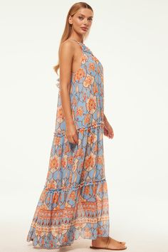 An event-ready maxi for all your special occasions, the Lala dress is handcrafted from a gorgeous caged floral print chiffon in a lovely light blue chiffon. This trapeze silhouette is defined by a chic high neckline with adjustable tie back detail. Double-edged ruffles adorn the neckline and tiered maxi skirt. Pair this standout style with sandals and a chic clutch for the perfect elevated look. Made in the USADry Clean100% Poly Chiffon Model Measurements: Height 5'10, Waist 26", Bust 33", Hips Trapeze Silhouette, Tiered Maxi Skirt, Floral Print Chiffon, Print Chiffon, High Neckline, Tie Backs, Tie Back, Model Measurements, Ruffles