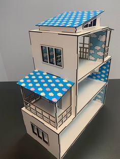 a paper model of a three story house with blue and white polka dots on the roof