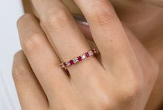 a woman's hand with a pink and white diamond ring on her left finger