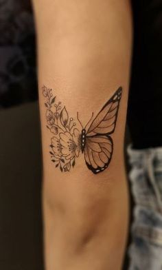 a woman's arm with a butterfly and flowers tattoo on the left side of her leg