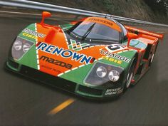 an orange and green race car driving down the road