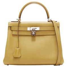 Hermès Kelly 28 Cumin Swift PHW turnlock crossbody top handle bag Reference: LNKO/A02393 Brand: Hermès Model: Kelly 28 Material: Leather, Metal Color: Yellow Pattern: Solid Closure: Turnlock Lining: Yellow Leather Extra Details: Square M stamp from 2009. Hermès Kelly 28cm bag with detachable shoulder. Palladium silver hardware. Made in: France CONDITION: Condition: Good, this item was pre-owned and is in good condition. Please refer to image gallery for thorough condition check. Micro scratches Bag Reference, Hermes Kelly 28, Yellow Pattern, Yellow Leather, Handle Bag, Image Gallery, Silver Hardware, Fashion Handbags, Top Handle