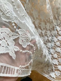 This is a white net, white fabric embroidered with intricate floral motifs from one corner to another. The embroidery is done very neatly so that this can also be used from the backside. There is an embroidered ladder motif on both long edges.  This would make a gorgeous chuppah canopy as it looks like a canopy made from flowers. The embroidery on the net fabric shows on the reverse and front sides.  MATERIAL = soft net, but intricate embroidery adds texture and weight to the fabric.  USAGE = We White Embroidered Fabric With Lace Trim, White Embroidered Fitted Fabric With Lace Trim, Fitted White Embroidered Fabric With Lace Trim, White Embroidered Lace Fabric, White Lace Embroidered Fabric, Traditional White Lace With Intricate Embroidery, Spring White Embroidered Fabric With Lace Work, Embroidered White Lace For Spring, Spring Embroidered White Lace