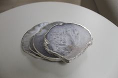 three pieces of silver sitting on top of a white table