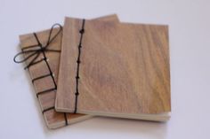 two wooden notebooks tied to each other