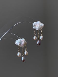 Crafted with exquisite Baroque pearls, each earring resembles a fluffy cloud adorned with delicate raindrops, symbolizing the tears of longing and the hope of reunion in a long-distance relationship. These earrings are more than just jewelry; they are a reflection of the enduring bond shared between lovers separated by miles. With every sway, they whisper tales of love's resilience and the promise of a brighter tomorrow. Wear these earrings as a reminder of the love that transcends distance, as Rain Drop Jewelry, Unique Dangle Pearl Earrings, Unique Pearl Dangle Earrings, Unique Pearl Earrings As Gift, Unique Pearl Earrings For Gift, Baroque Pearl Dangle Earrings For Gift, Handmade Baroque Pearl Earrings For Gift, Baroque Pearl Chain Earrings Gift, Baroque Pearl Earrings As A Gift