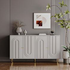 a white cabinet sitting next to a potted plant on top of a hard wood floor