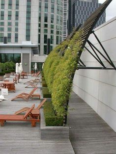 an outdoor seating area with wooden benches and plants growing on the side of the building