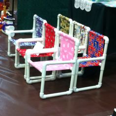 four colorful chairs sitting on top of a brown floor