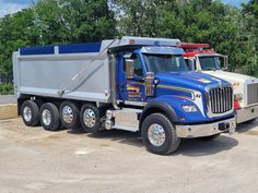 a blue dump truck parked in a parking lot