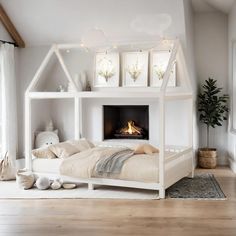 a white bed with a fireplace in the middle and pillows on the bottom bunk beds