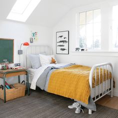 a child's room with a bed, desk and chalkboard