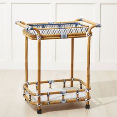 a rattan and wicker serving cart with blue trimmings on the handles