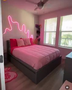 a bed room with a neatly made bed and a pink comforter on top of it