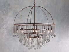 a chandelier hanging from the ceiling in a room with concrete walls and flooring