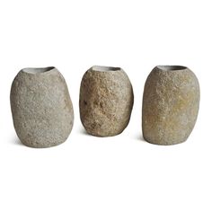 three stone vases sitting next to each other