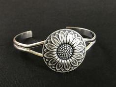 Silver Sunflower Cuff.... I have attached a beautiful oxidized silver sunflower stamping to the center of a silver metal cuff base. The sunflower comes from very old tooling and is absolutely beautiful! The brass sunflower stamping is lead and nickel free and is made in the USA! Fits: medium size wrist Sunflower - 30-32mm in diameter approx. Your Bohemian sunflower cuff will come to you gift wrapped! Give this to someone for Valentine's Day! You will find many brooches listed here! https://www.e Presents For Girlfriend, Jewelry Bracelets Silver, Silver Jewelry Design, Timeless Accessories, Nature Bracelets, Beautiful Bracelet, Girlfriend Gifts, Cuff Bracelet, Bridesmaid Gifts